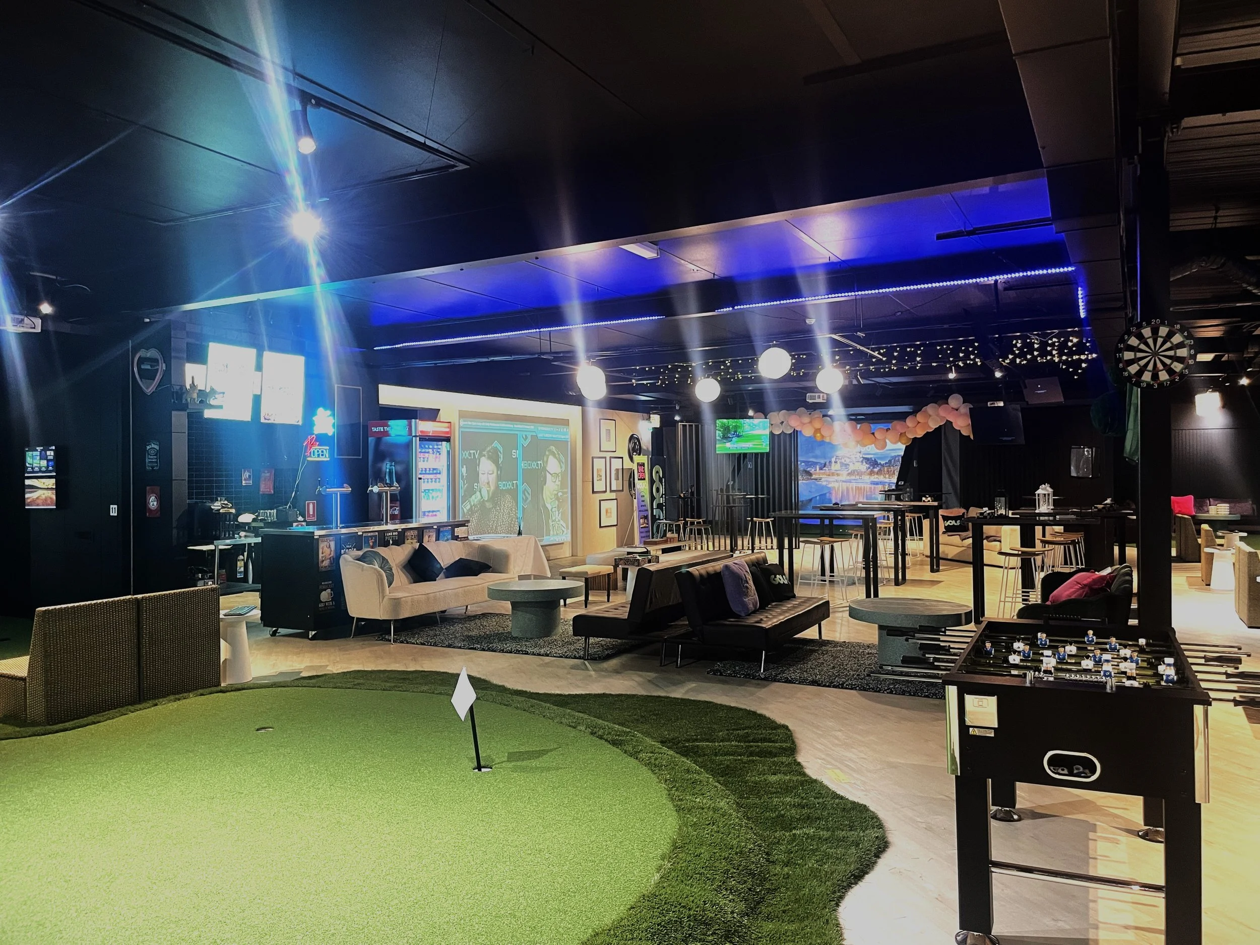 The real Golf Q indoor golf facility in Meadowbank with green practice areas and TrackMan bays